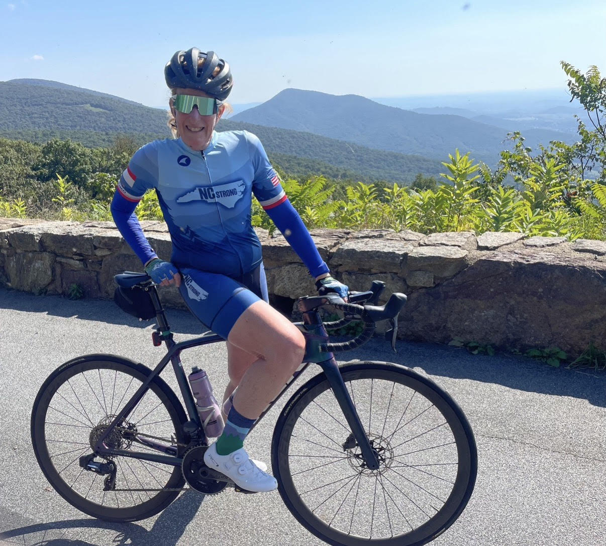 Libby Skinner with her bike at a mountain overlook